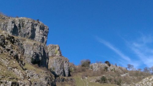 Low angle view of rocky mountains against sky