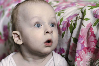 Close-up portrait of cute baby girl in bed
