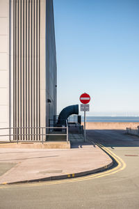 Road sign against clear blue sky