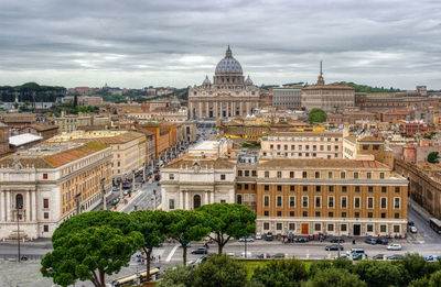 Buildings in city against cloudy sky