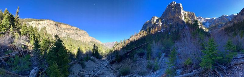 Panoramic view of rocky mountains against blue sky