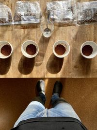 Low section of man with coffee cup on floor