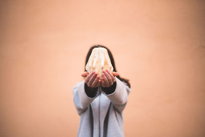 Midsection of woman standing against wall