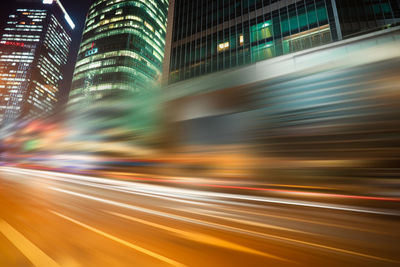 Light trails on street amidst buildings at night