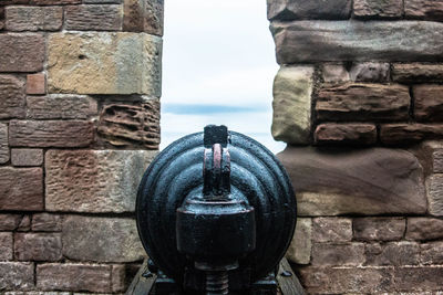 Close-up of coin-operated binoculars by sea against sky