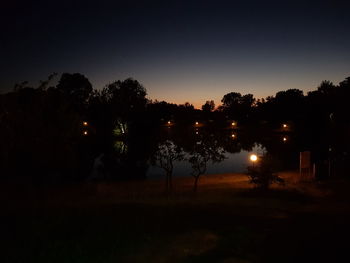 Silhouette trees against sky at night