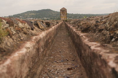 Drain at field against sky