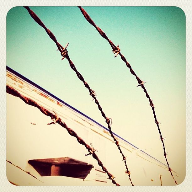 transfer print, auto post production filter, low angle view, clear sky, hanging, close-up, sky, built structure, no people, day, outdoors, building exterior, architecture, metal, sunlight, protection, nature, red, plant, safety