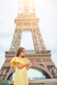 Woman standing with tower in background
