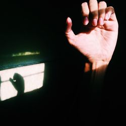 Close-up of hand against the dark