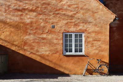 Leaning bike against orange wall