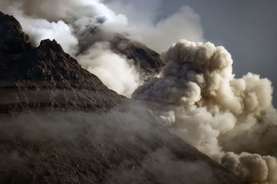 Smoke emitting from volcanic mountain against sky