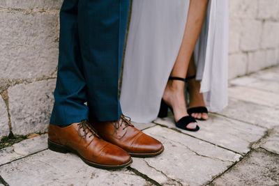 Low section of friends standing on footpath