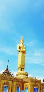 Low angle view of statue against building against sky