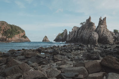 Scenic view of rock formation and sea against sky