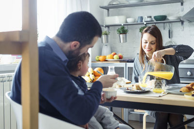 Family having breakfast at table in kitchen