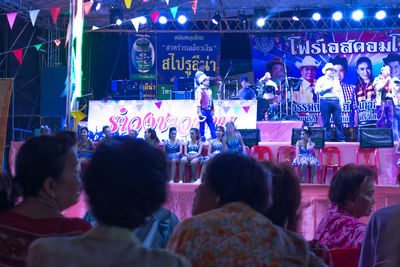 People at music concert in city at night