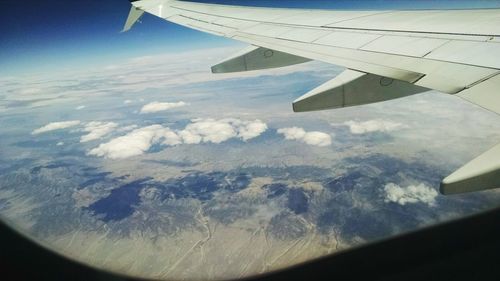 Cropped image of airplane wing over landscape