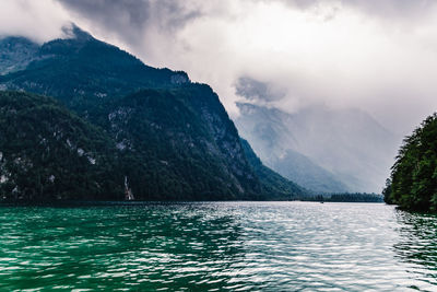 Scenic view of lake by mountains against sky