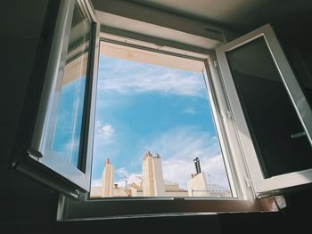 Low angle view of glass building against sky