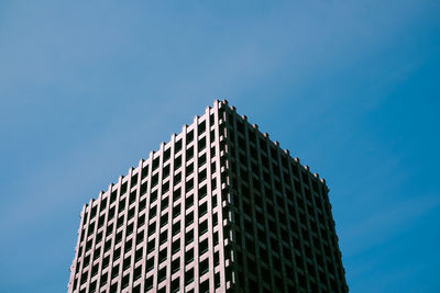 Low angle view of office building against blue sky