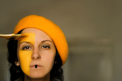 Close-up portrait of woman yellow applying face paint