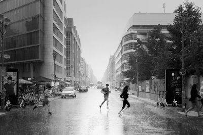 People walking on street amidst buildings in city