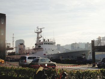 Cars on street by buildings against sky