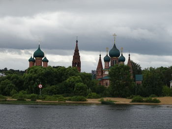 View of building by river against sky