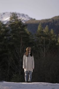 Full length portrait of young woman standing on land
