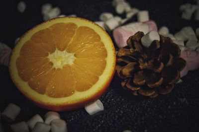 Close-up of pine cone and orange amidst marshmallows