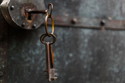 Close-up of rusty keys hanging in lock