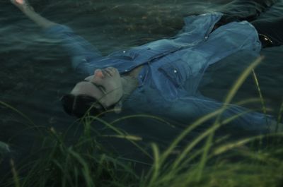 Man lying in river at forest