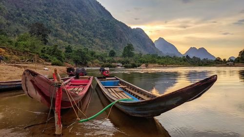 Boats moored on shore against sky