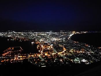 Illuminated cityscape against sky at night