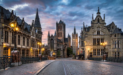 Street amidst buildings against sky at dusk