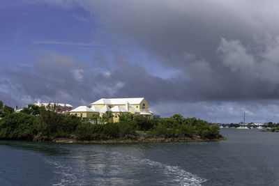 Houses by sea against sky