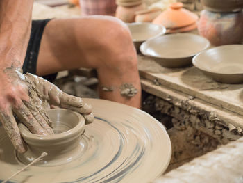 Potter working on wheel preparing pots