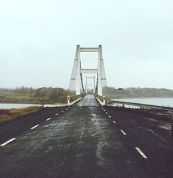 View of suspension bridge in city against sky