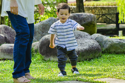 Full length of boys standing on grassland