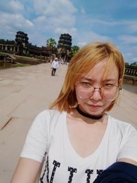 Young woman looking away against sky