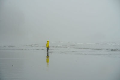 Man standing on beach against sky