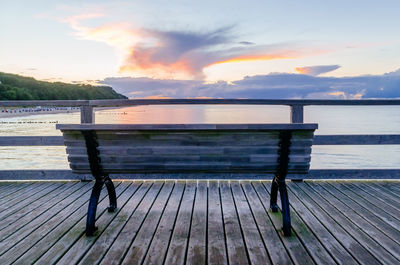 Empty bench overlooking calm lake