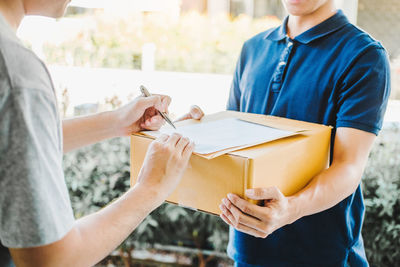 Midsection of couple holding camera in box