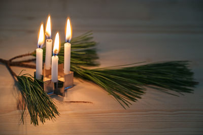 Close-up of illuminated candles on table