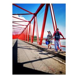 People walking on bridge against sky