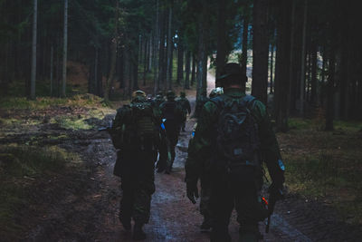 Rear view of soldiers walking in forest