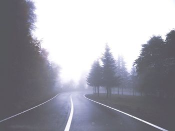 Road amidst trees against sky