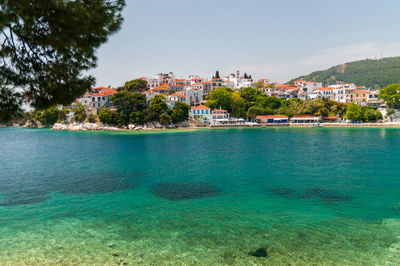 Scenic view of sea by buildings against sky