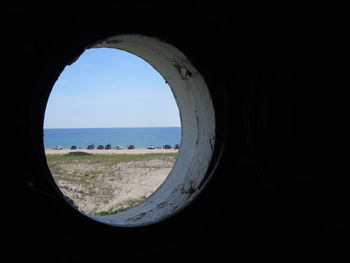 Scenic view of beach against clear sky seen through window